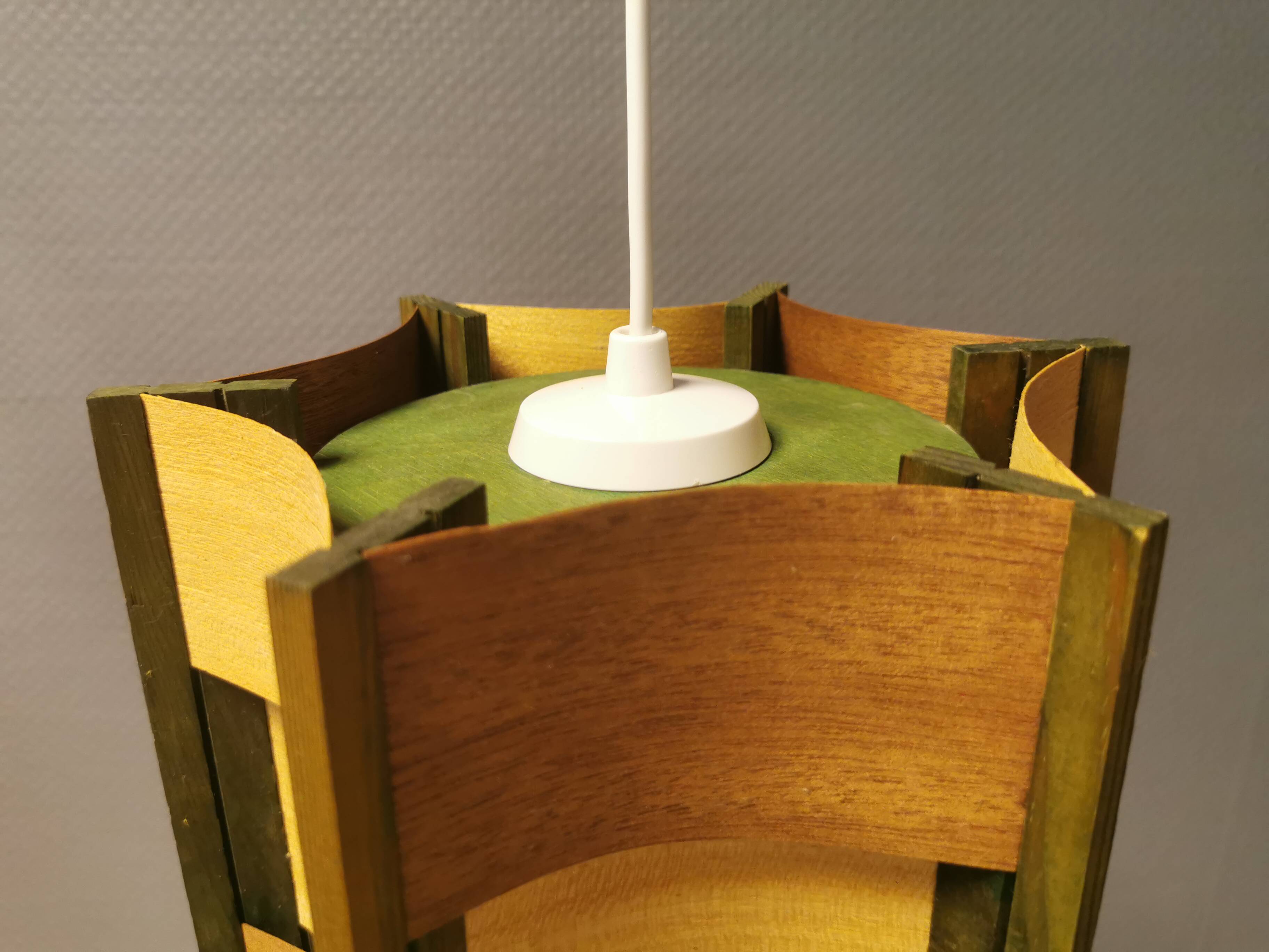 Older lamp in wood veneer, partially painted in green colour.