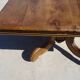 Old walnut table with a central leg.