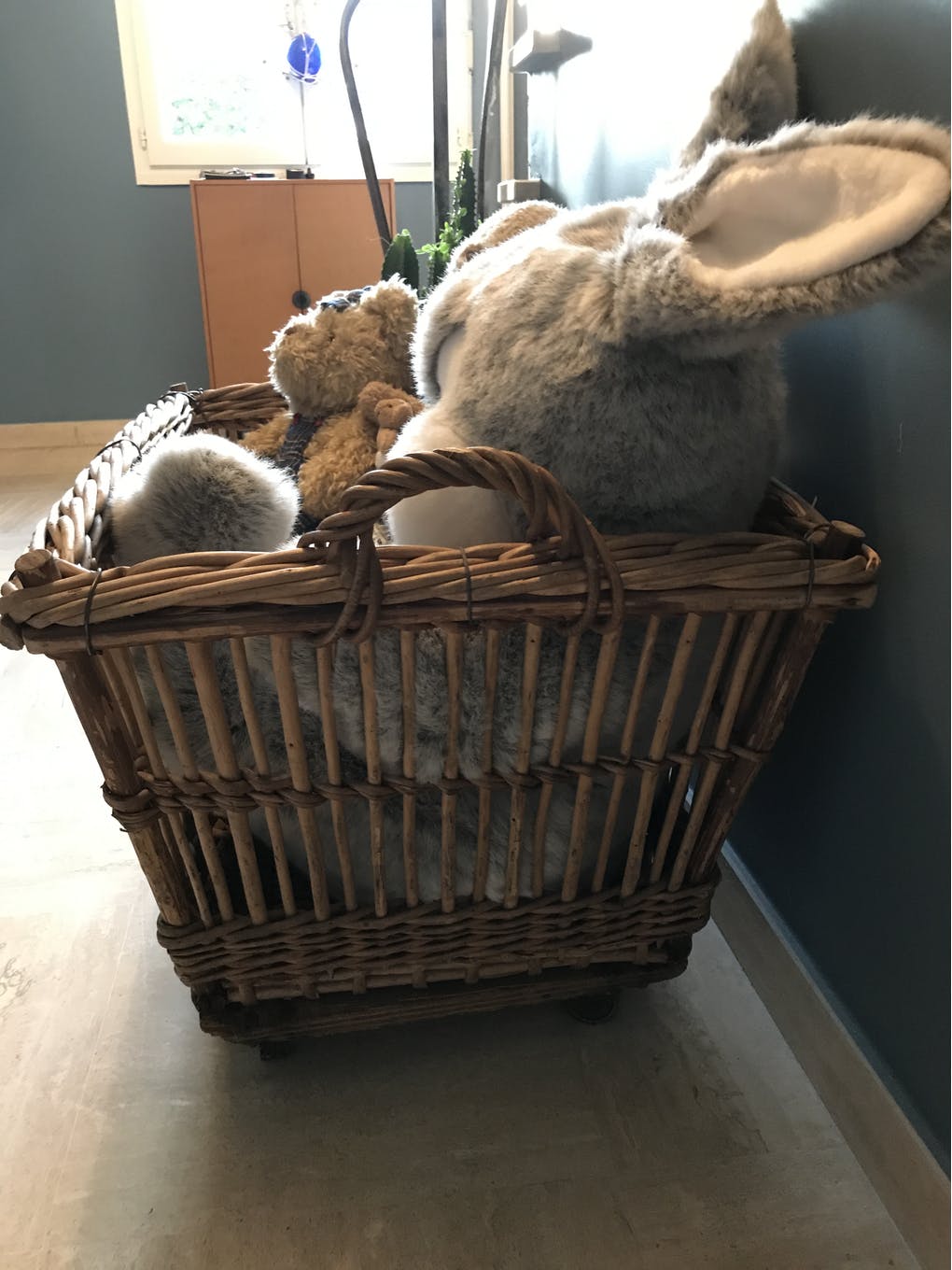 Rattan laundry basket on vintage wheels