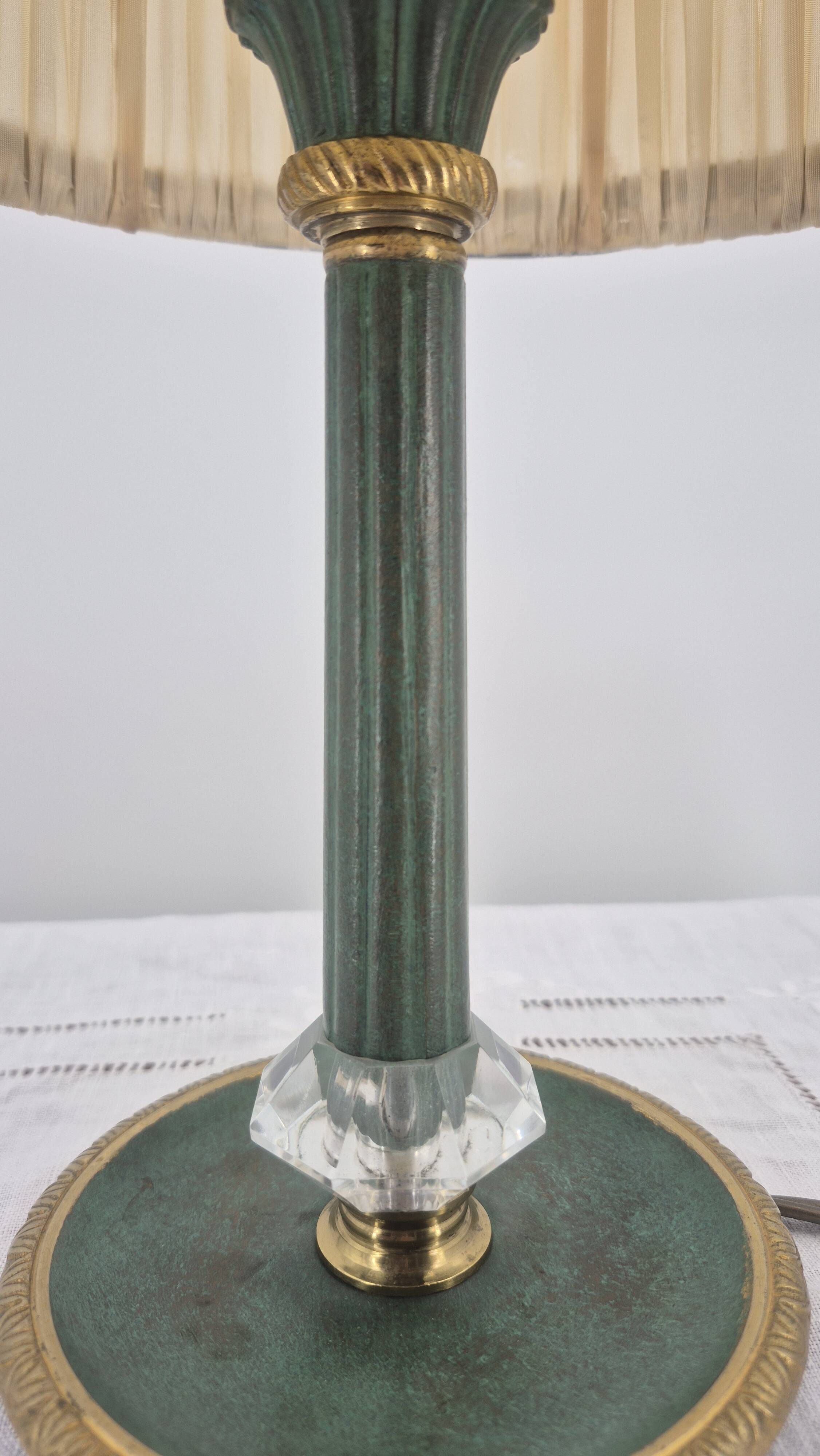 Brass table lamp with green patina and empire-style fabric shade.
