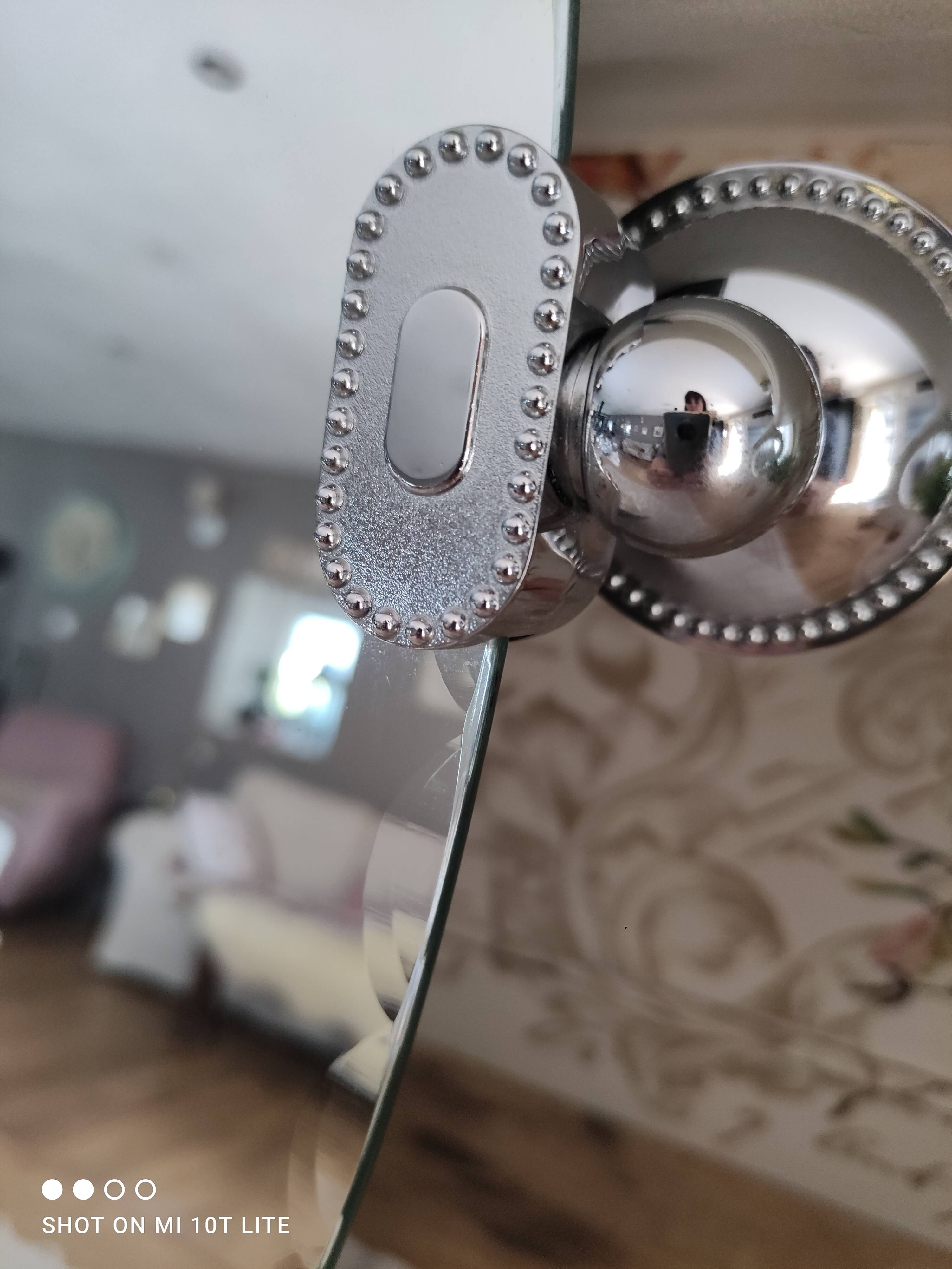 Miroir ovale biseauté vintage années 70 avec ses accroches murales en métal couleur argent