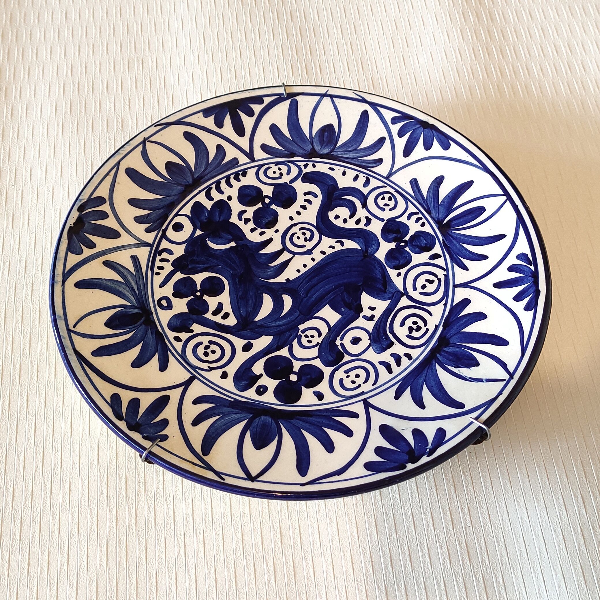 Hand-painted decorative plate decorated with a blue chimera pattern