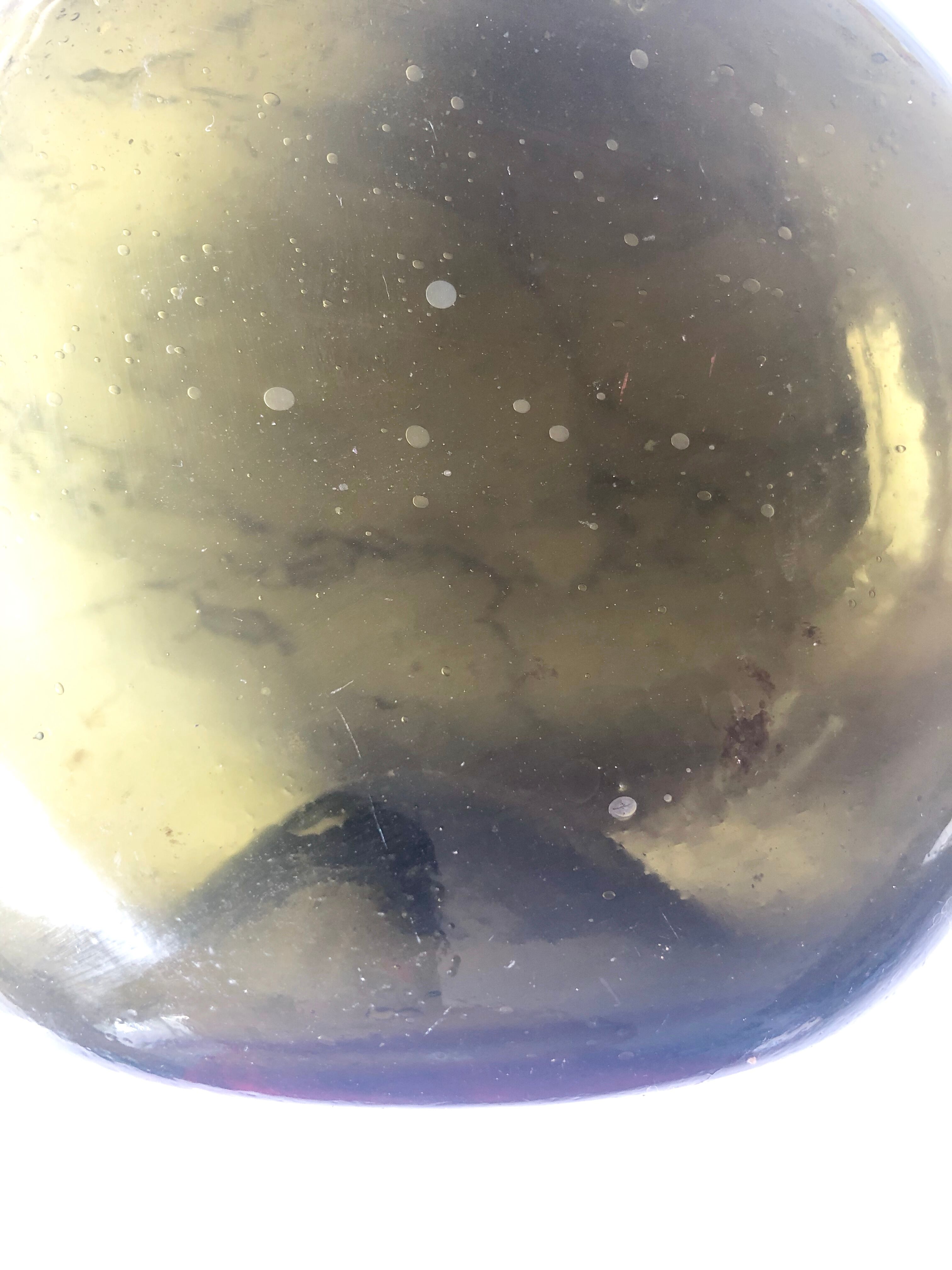 Old rum bottle in thick puffed glass in dark green color