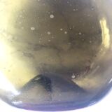 Old rum bottle in thick puffed glass in dark green color