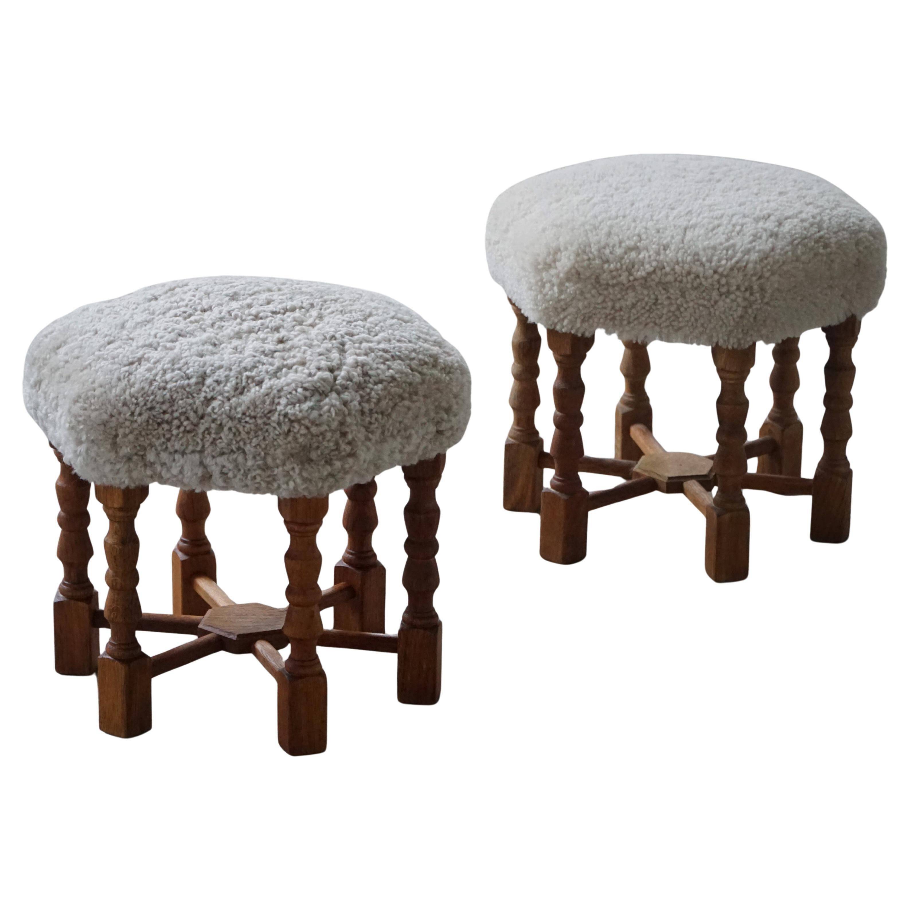 Pair of mid-century Danish oak stools with shearling lambswool upholstery, 1950s.