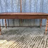 Antique farmhouse table in solid cherry wood with turned legs.