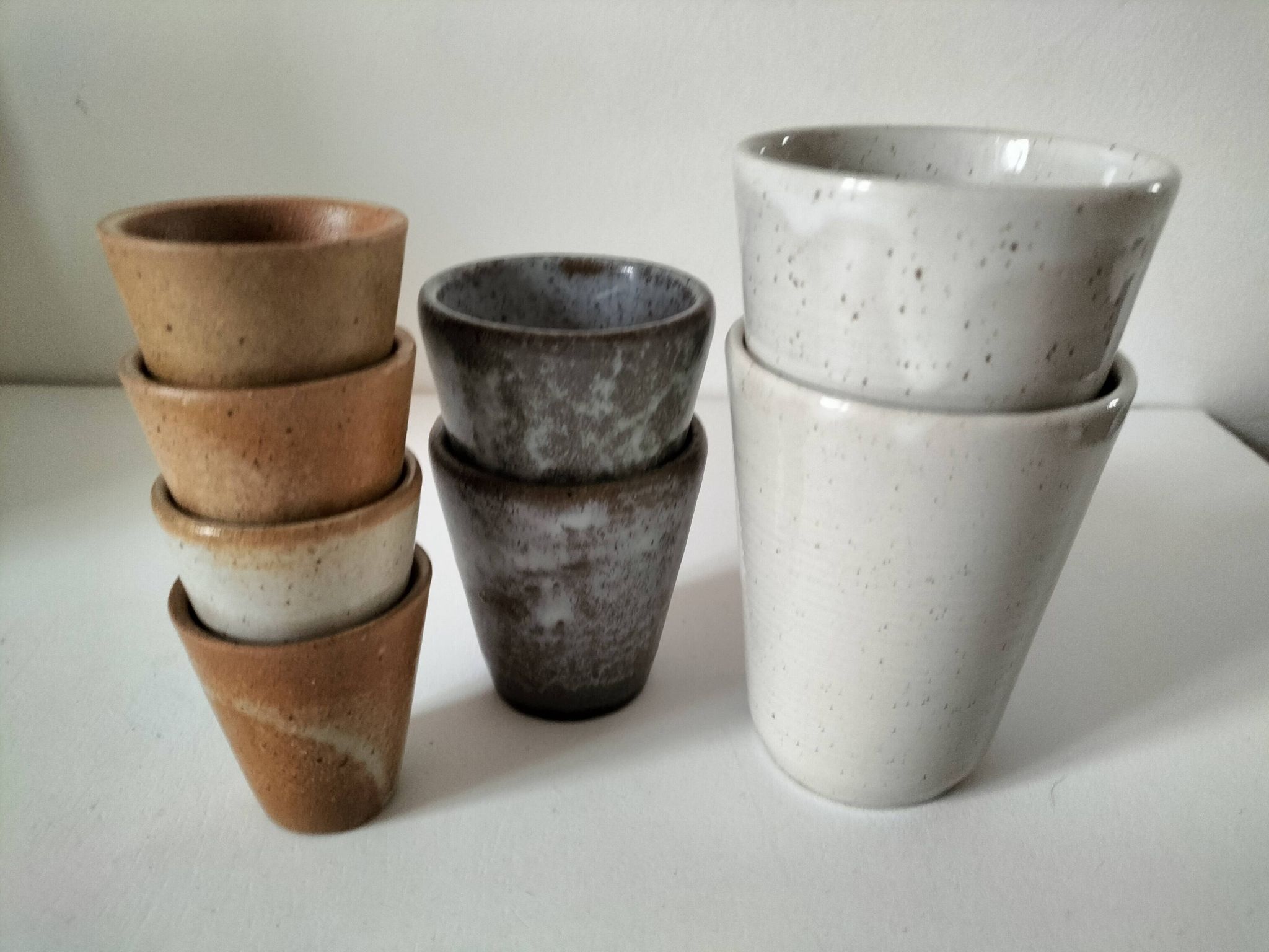 Set of 8 stoneware cups and a mug, shades of beige.