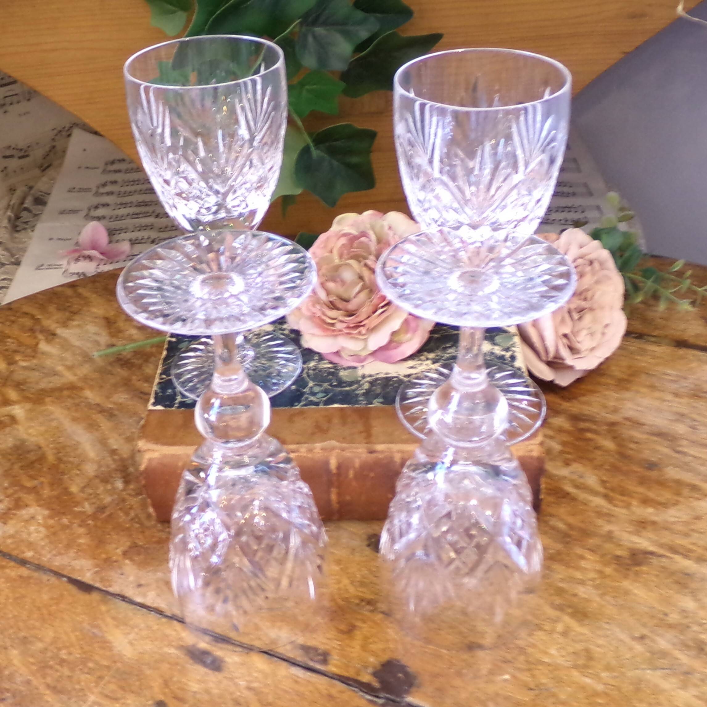 Cut crystal white wine glasses with a slender baluster-shaped stem.