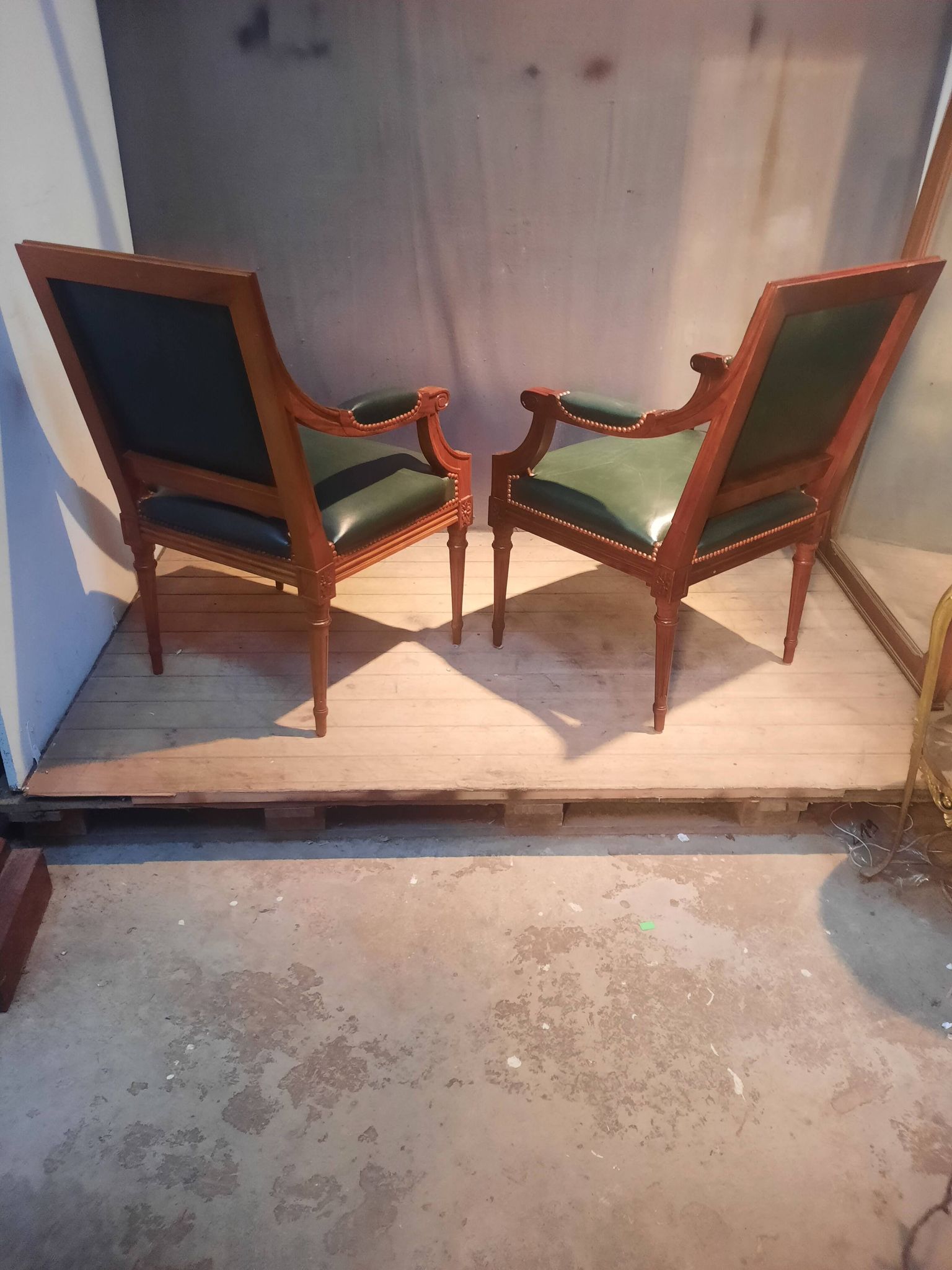 Pair of Louis XVI style armchairs upholstered in green leather.