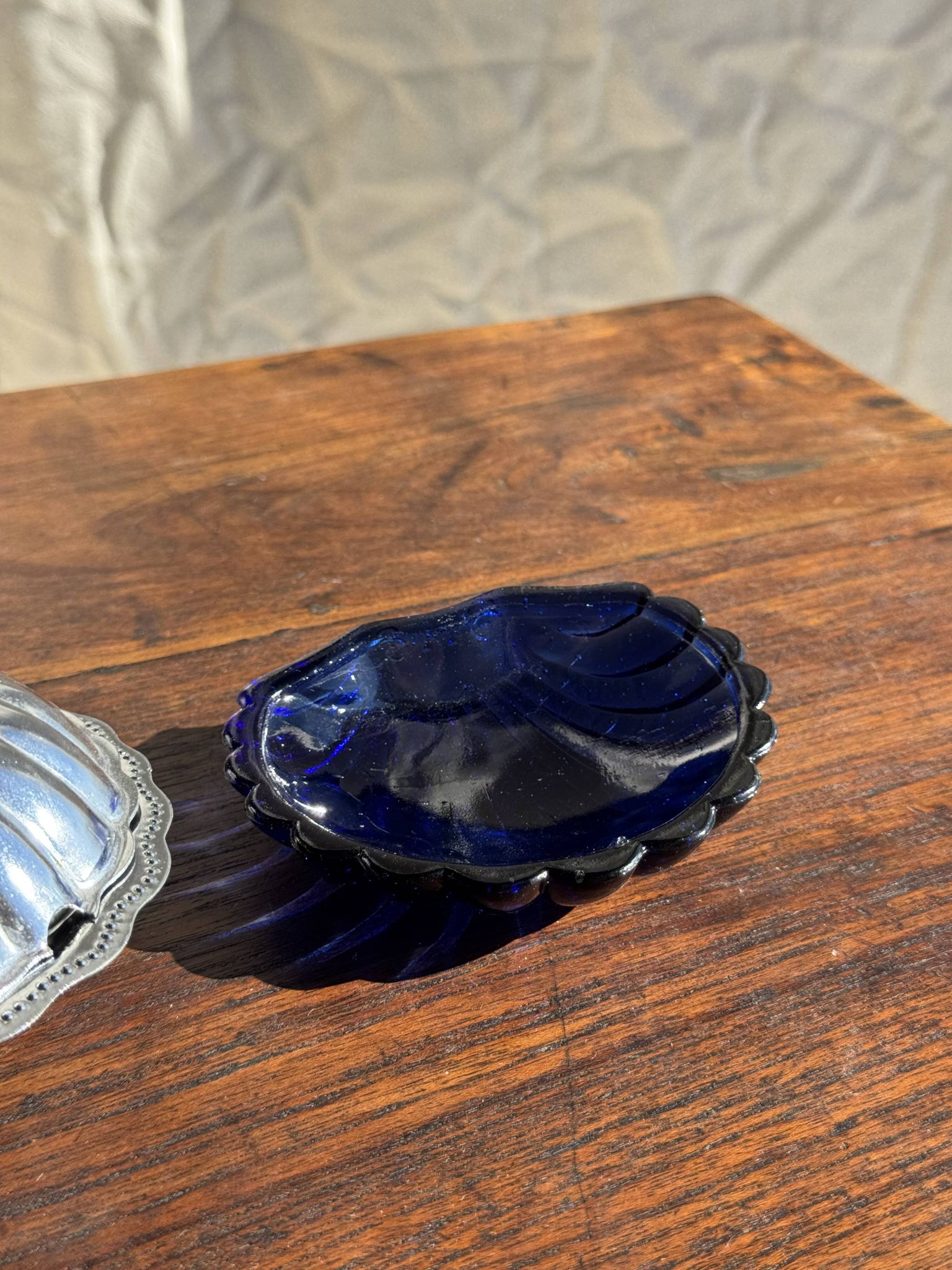 Vintage silver-plated shell butter dish with blue bowl.