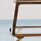 May include: A mid-century modern bar cart with a dark wood frame and two c