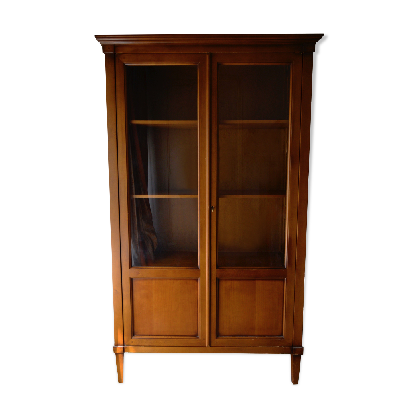 Straight molded clear wood cornice cabinet opening to two glass doors resting on  four sheath feet.