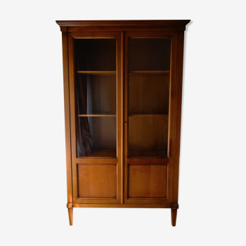 Straight molded clear wood cornice cabinet opening to two glass doors resting on  four sheath feet.