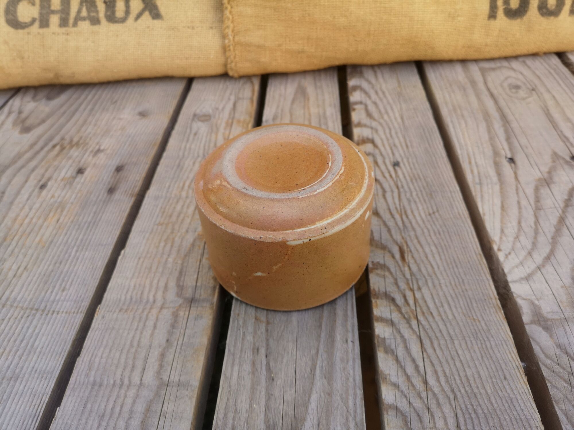 Brown sandstone cup with white spots