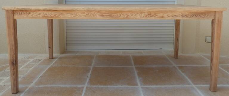 Large natural wood table with rectangular top supported by legs