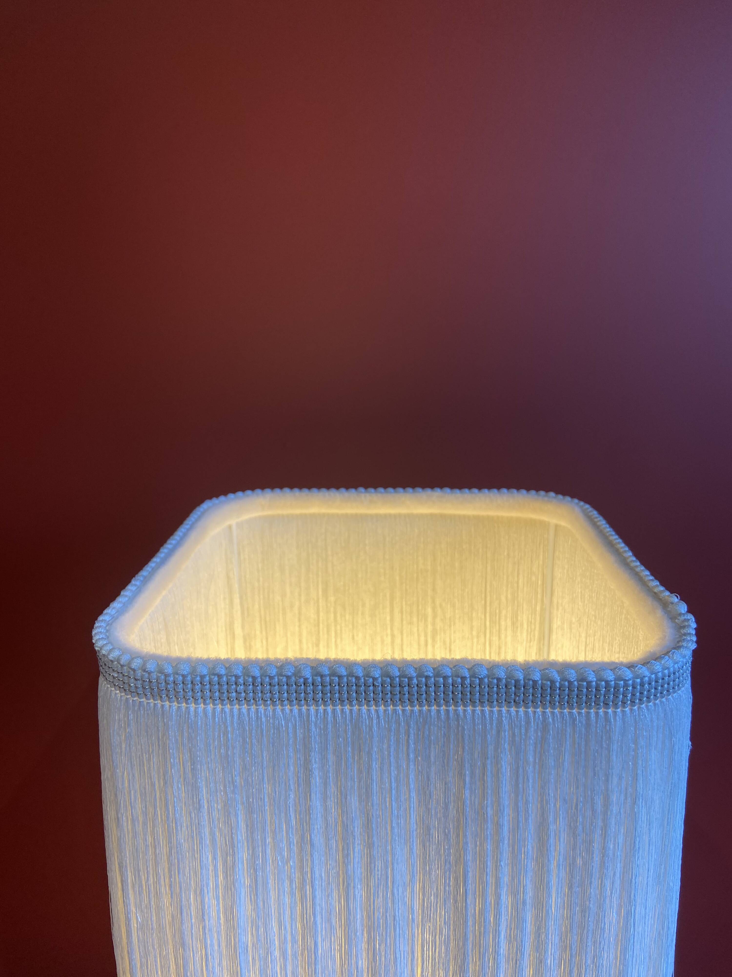 Beige marble stucco base, Houles white ecru fringed lampshade.