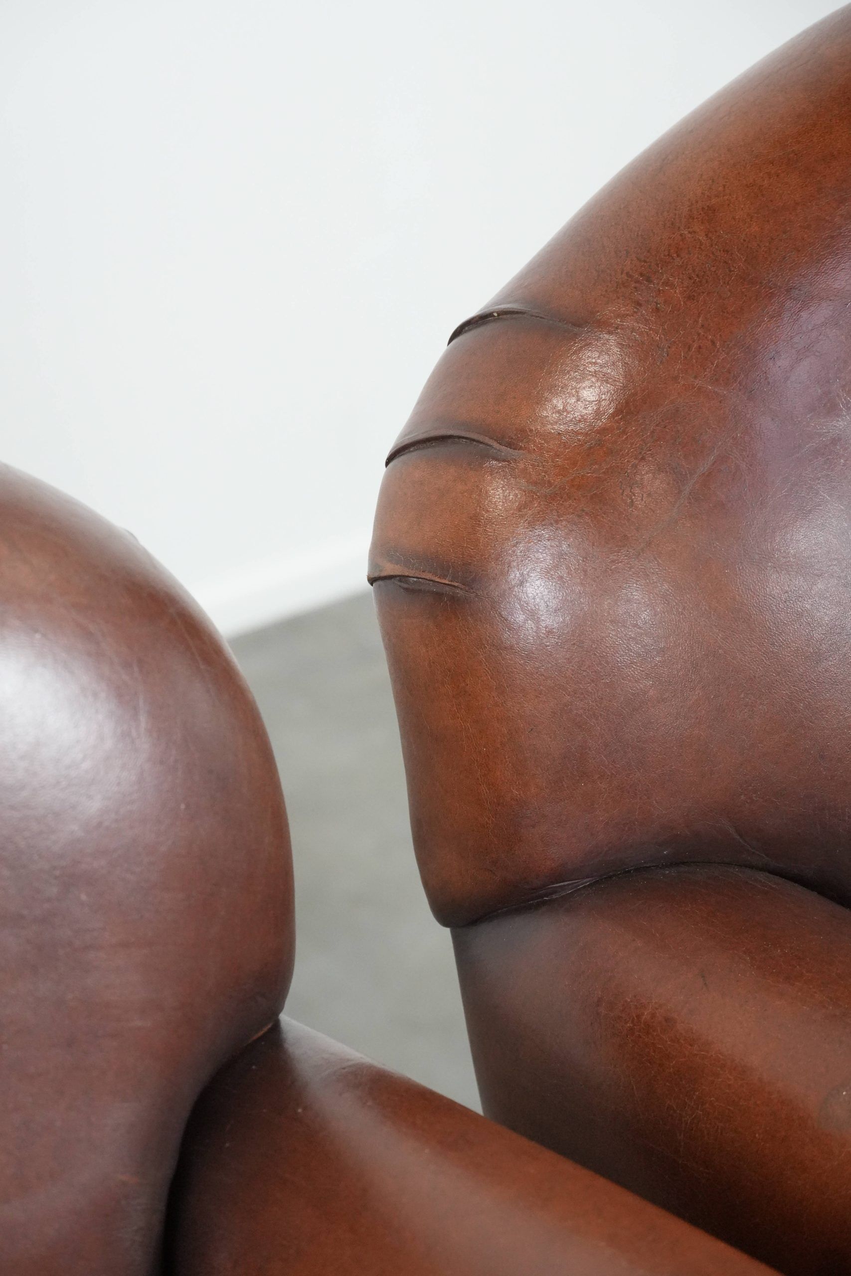 Ensemble de 2 fauteuils en peau de mouton au design art déco avec des couleurs chaudes.