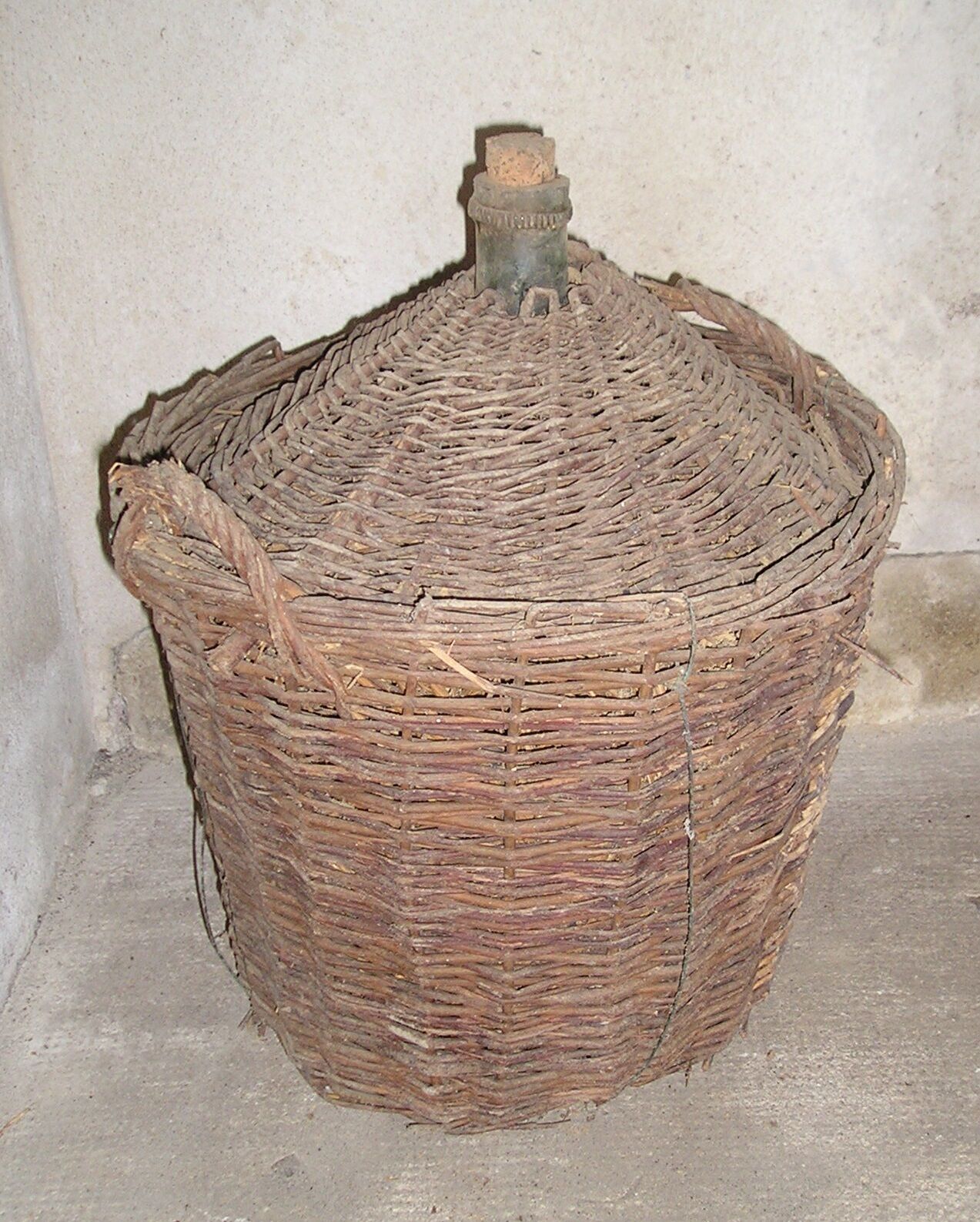 Old glass in her wicker basket demijohn