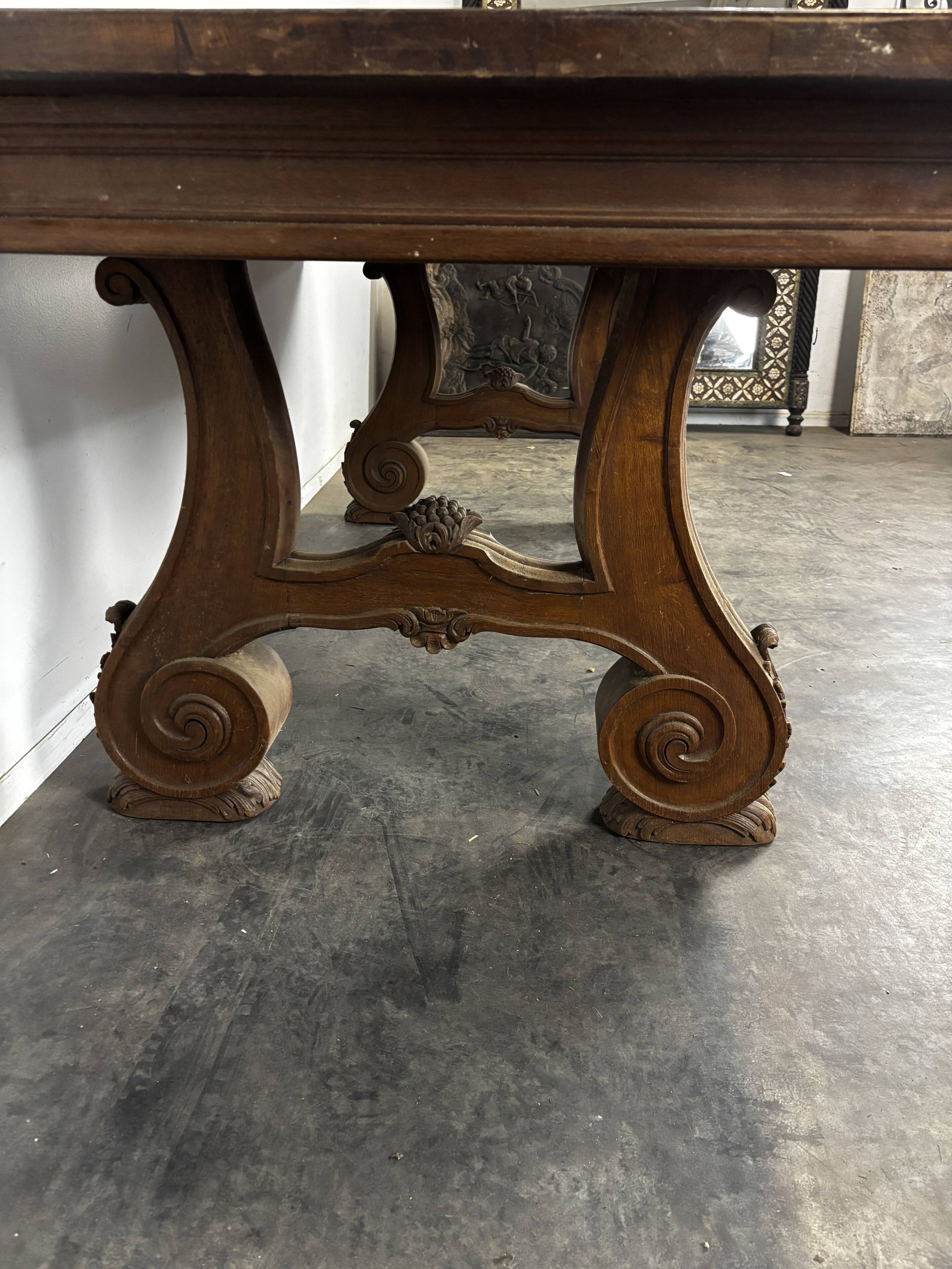 Renaissance-style oak dining table with lyre legs.