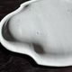 Antique oval-shaped white crackled faience plate with a scalloped edge.