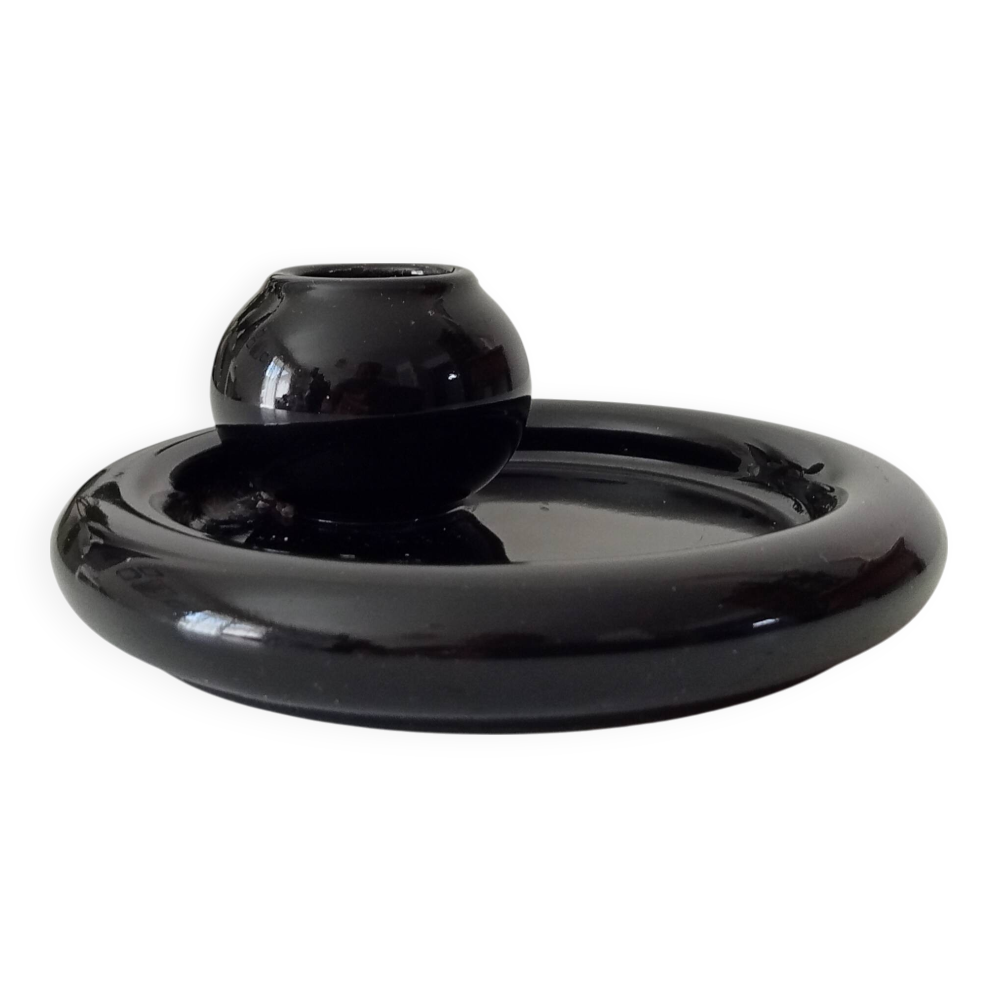 Vintage black ceramic candle holder on a bowl