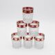 Six pressed glass whisky glasses with red and gold rims