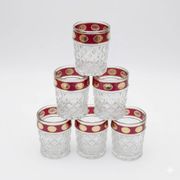 Six pressed glass whisky glasses with red and gold rims