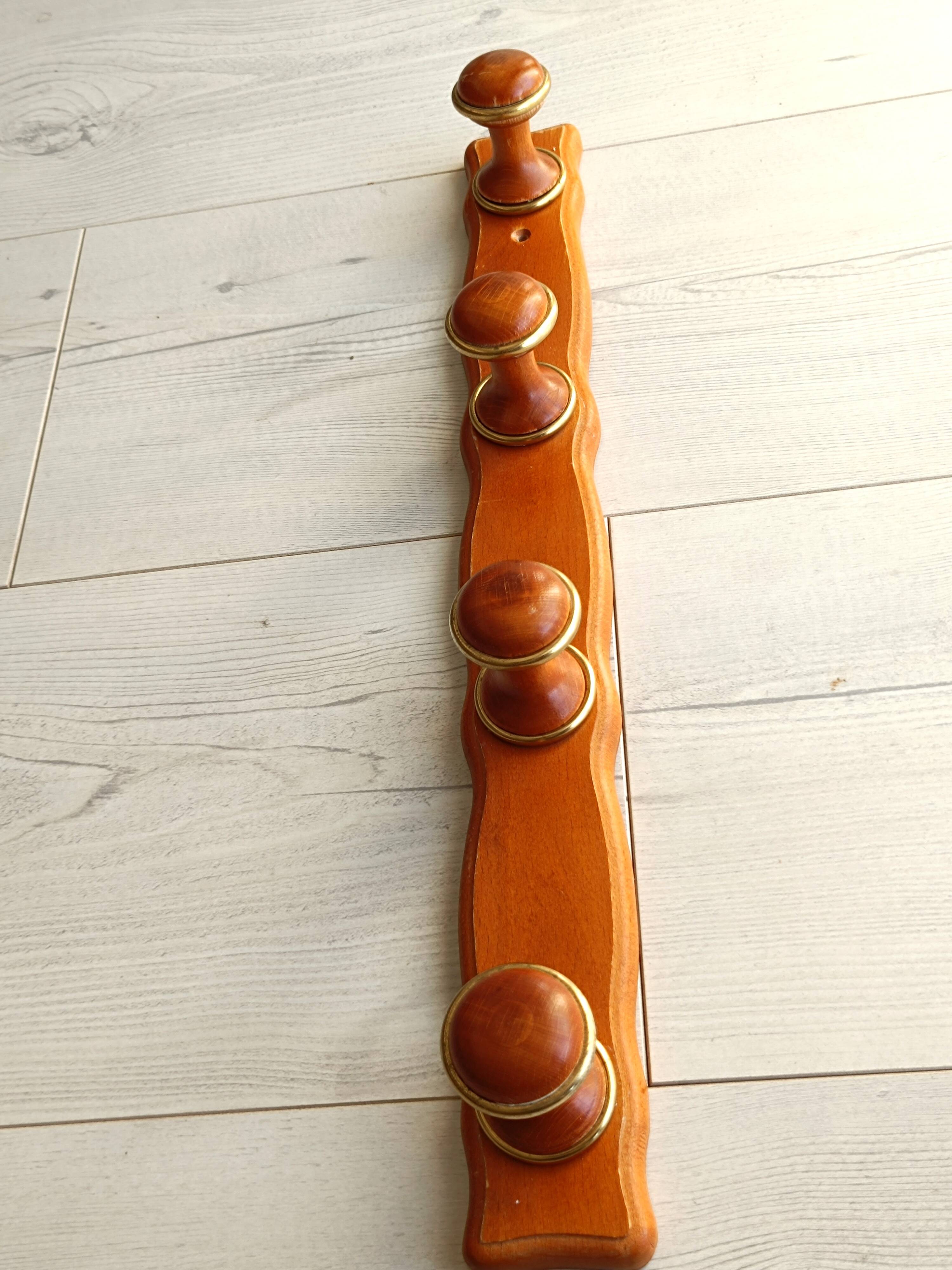 Wall-mounted coat rack in wood and brass