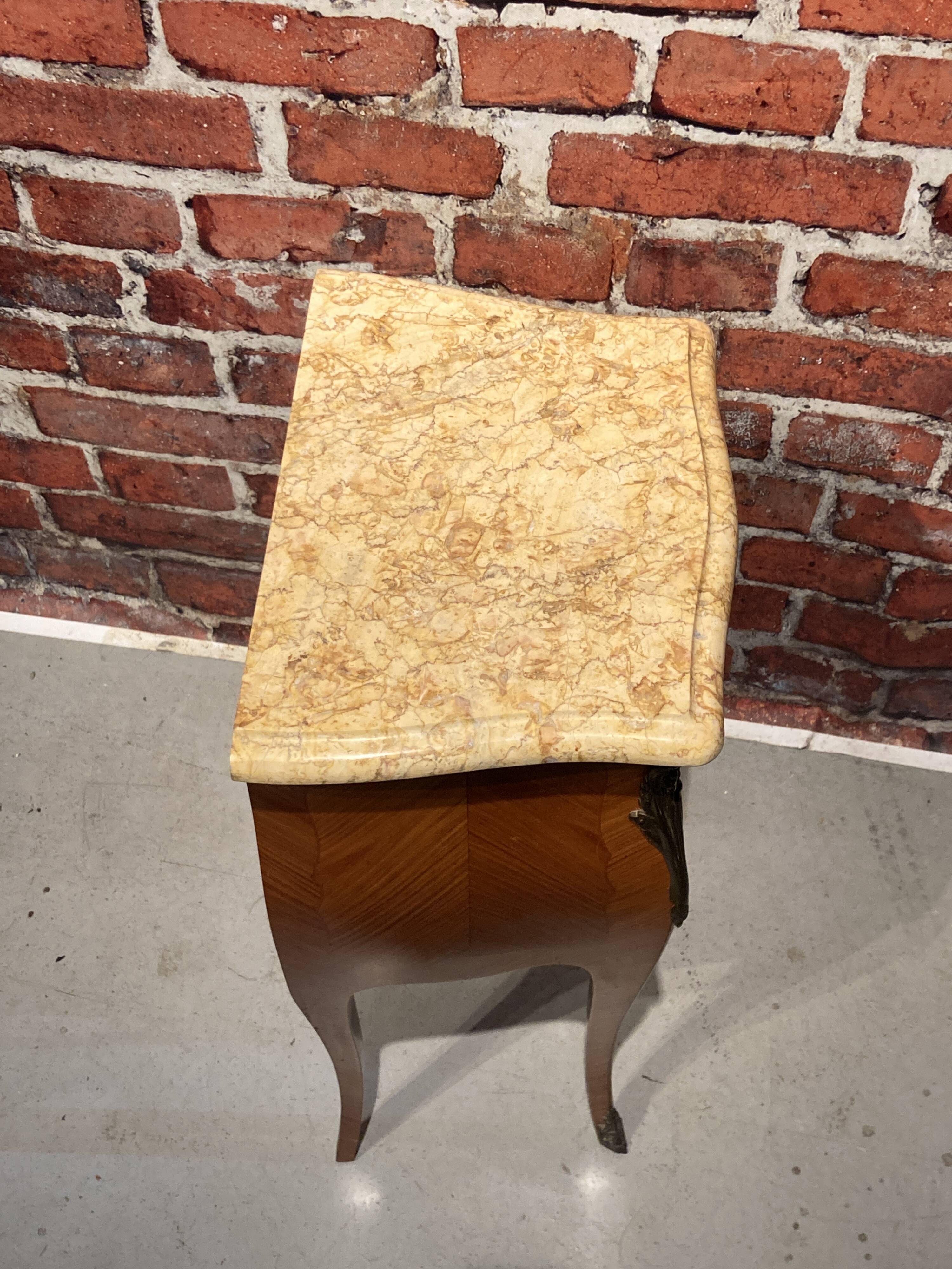 Wooden bedside table topped with a pink marble top