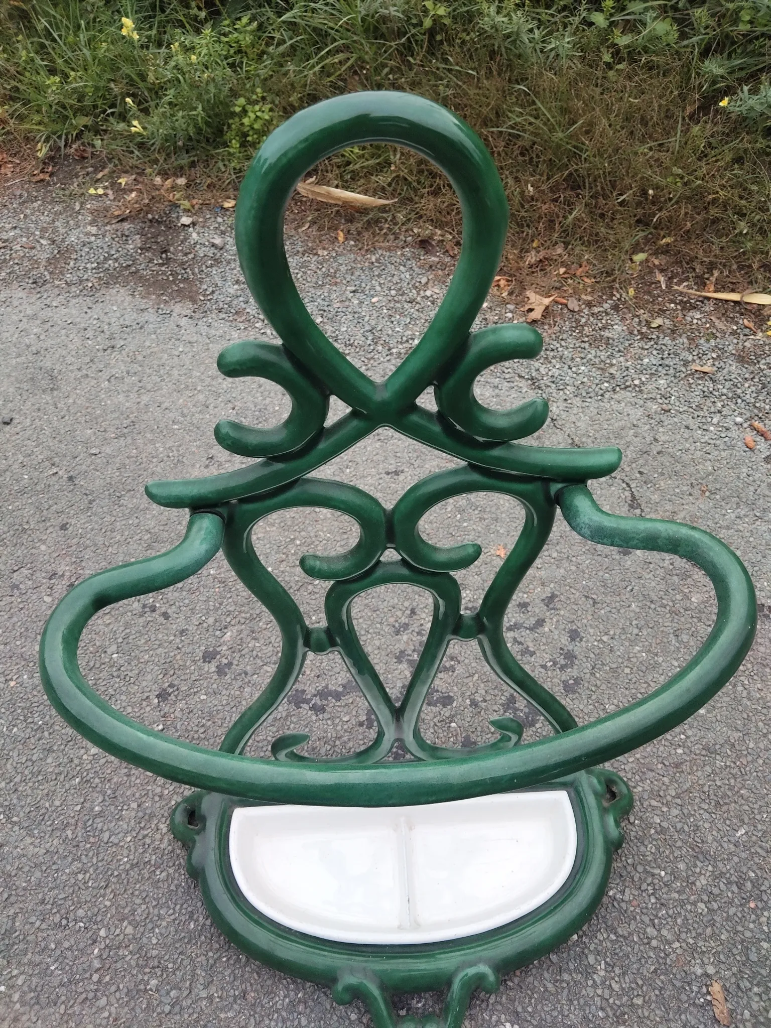Bottle green enamelled cast iron umbrella stand with a swirl design.