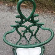 Bottle green enamelled cast iron umbrella stand with a swirl design.