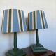 Pair of vintage wooden lamps with their striped beige, blue, and green shades.