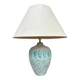 Vintage green ceramic table lamp with a worn lampshade.