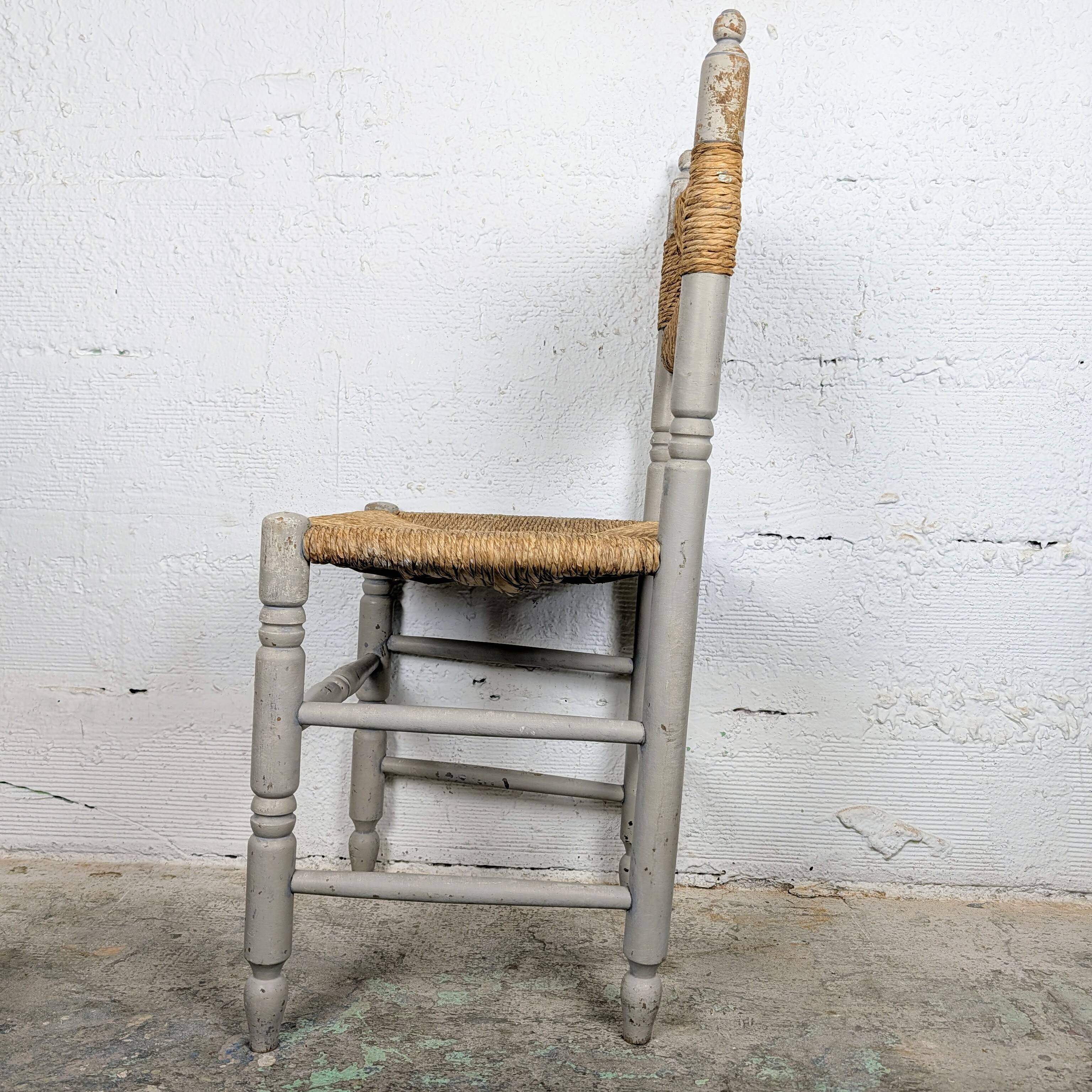 Rustic chair made of turned wood and straw.