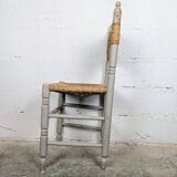 Rustic chair made of turned wood and straw.