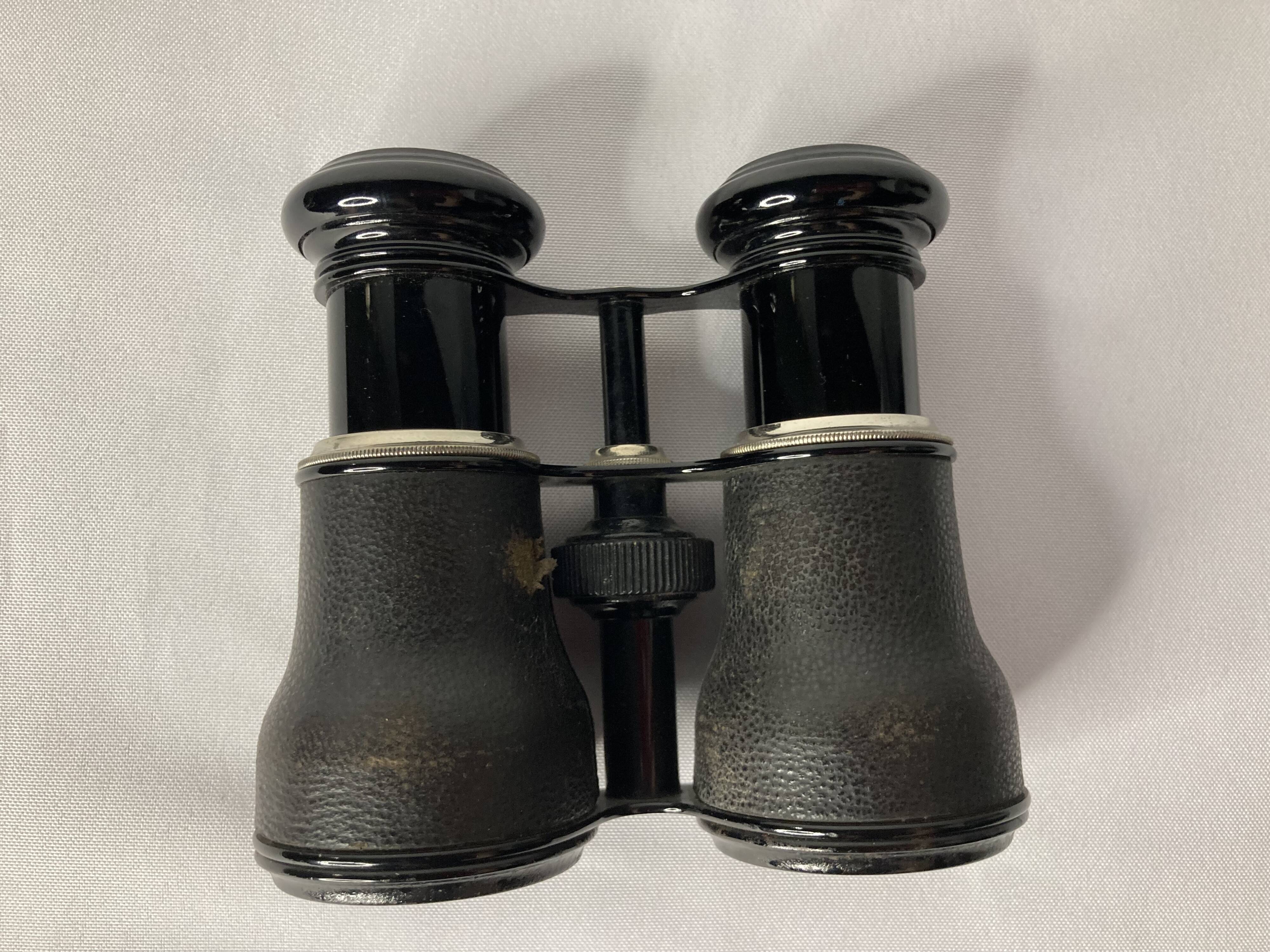 Old pair of binoculars sheathed leather black silver metal