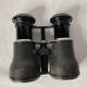 Old pair of binoculars sheathed leather black silver metal