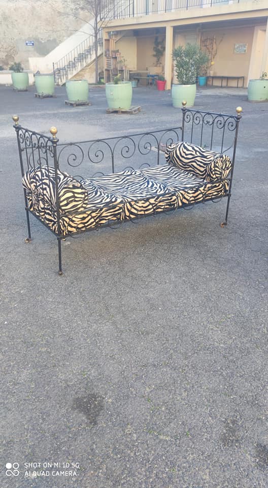 Lit d'enfant transformé en banquette en fer forgé sur roulettes