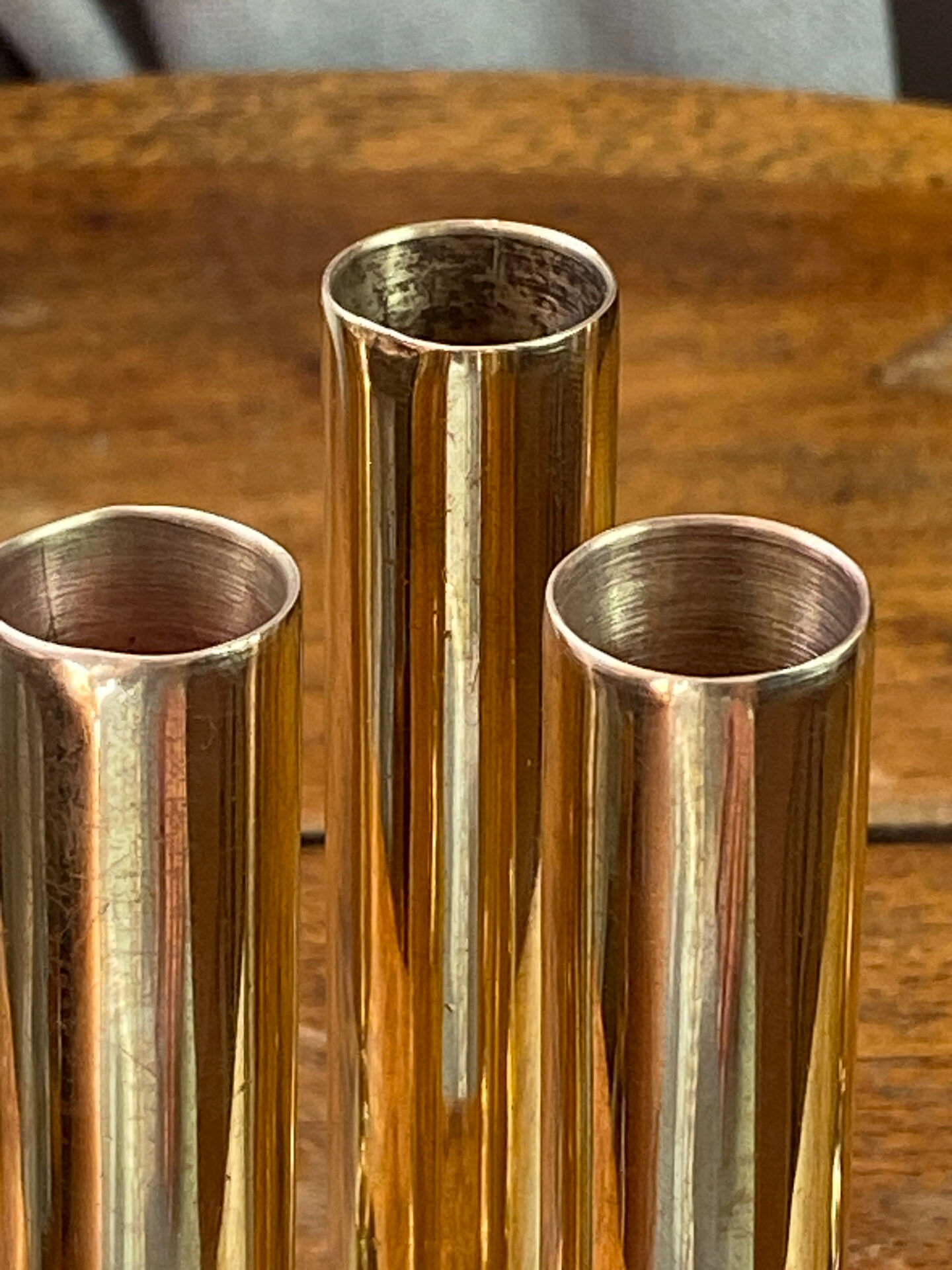 Set of candlesticks and tubular vases in solid brass.