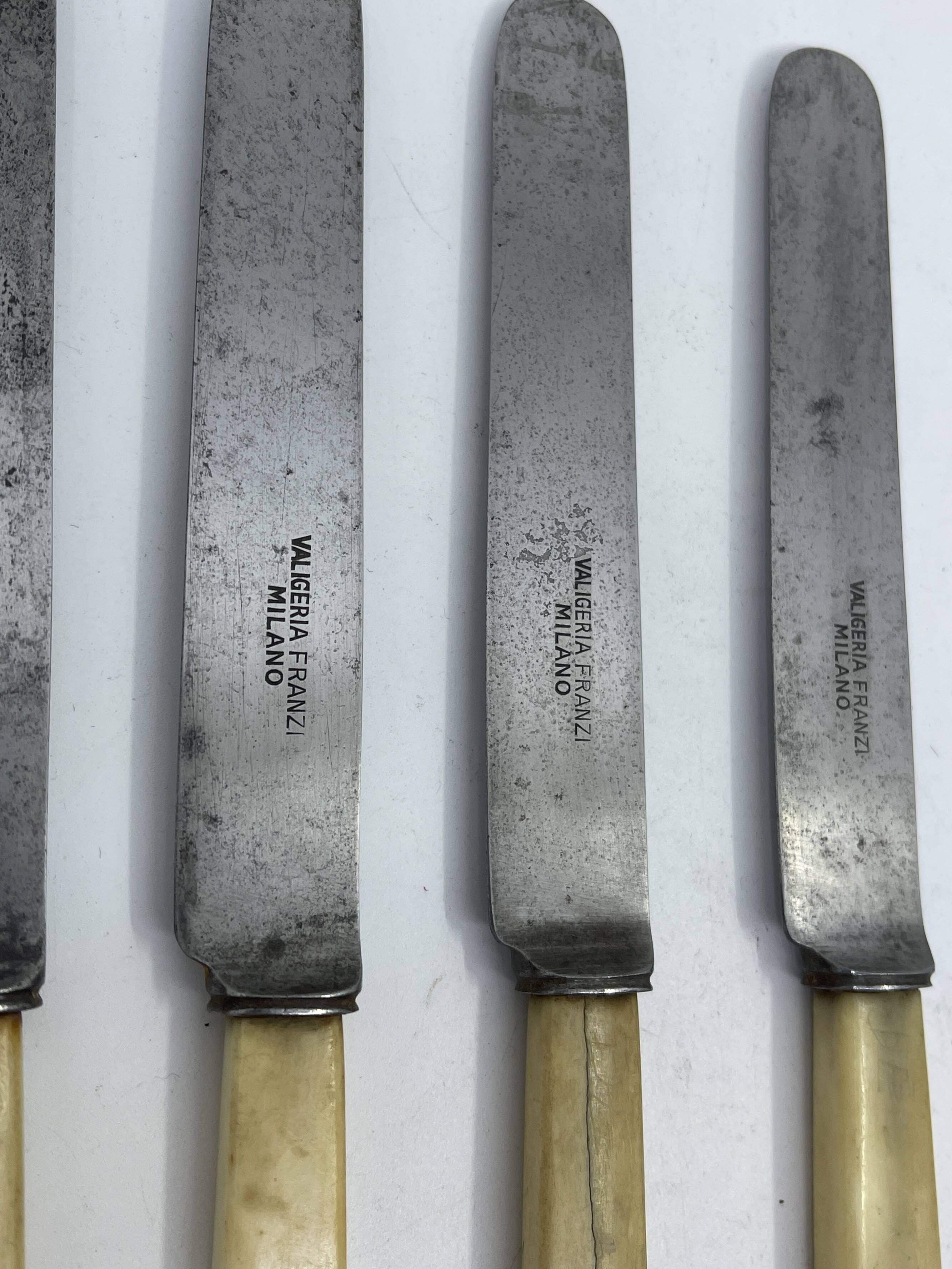Set of 4 dessert knives with rounded blades and smooth ivory resin handles.