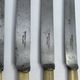 Set of 4 dessert knives with rounded blades and smooth ivory resin handles.