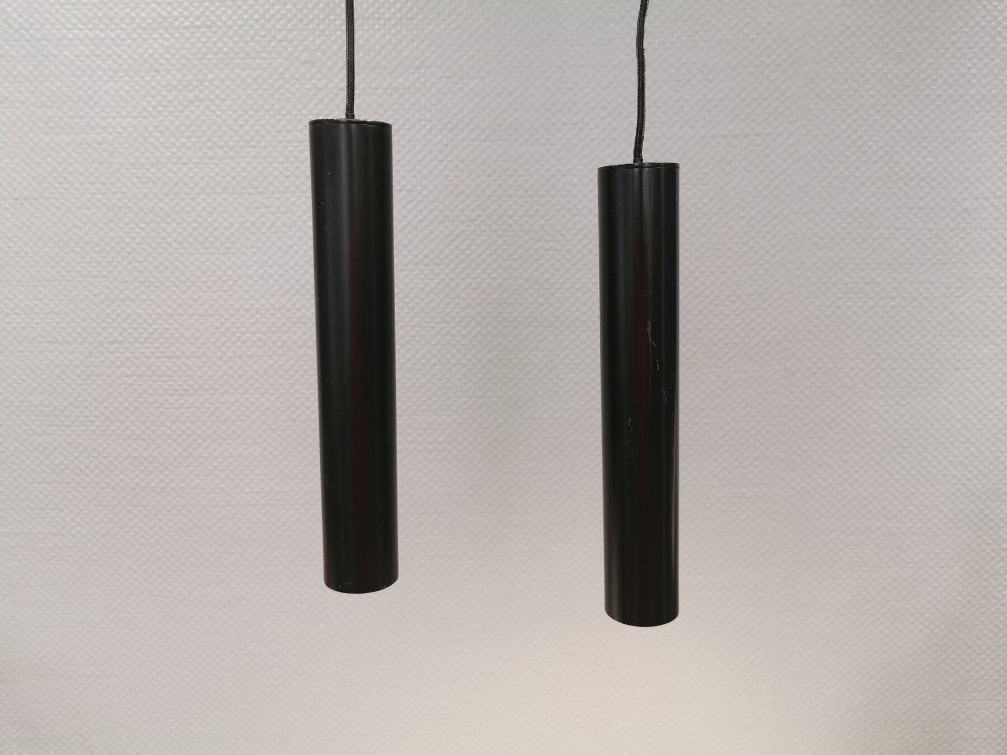 Two cylinder-shaped hanging lamps in black lacquer