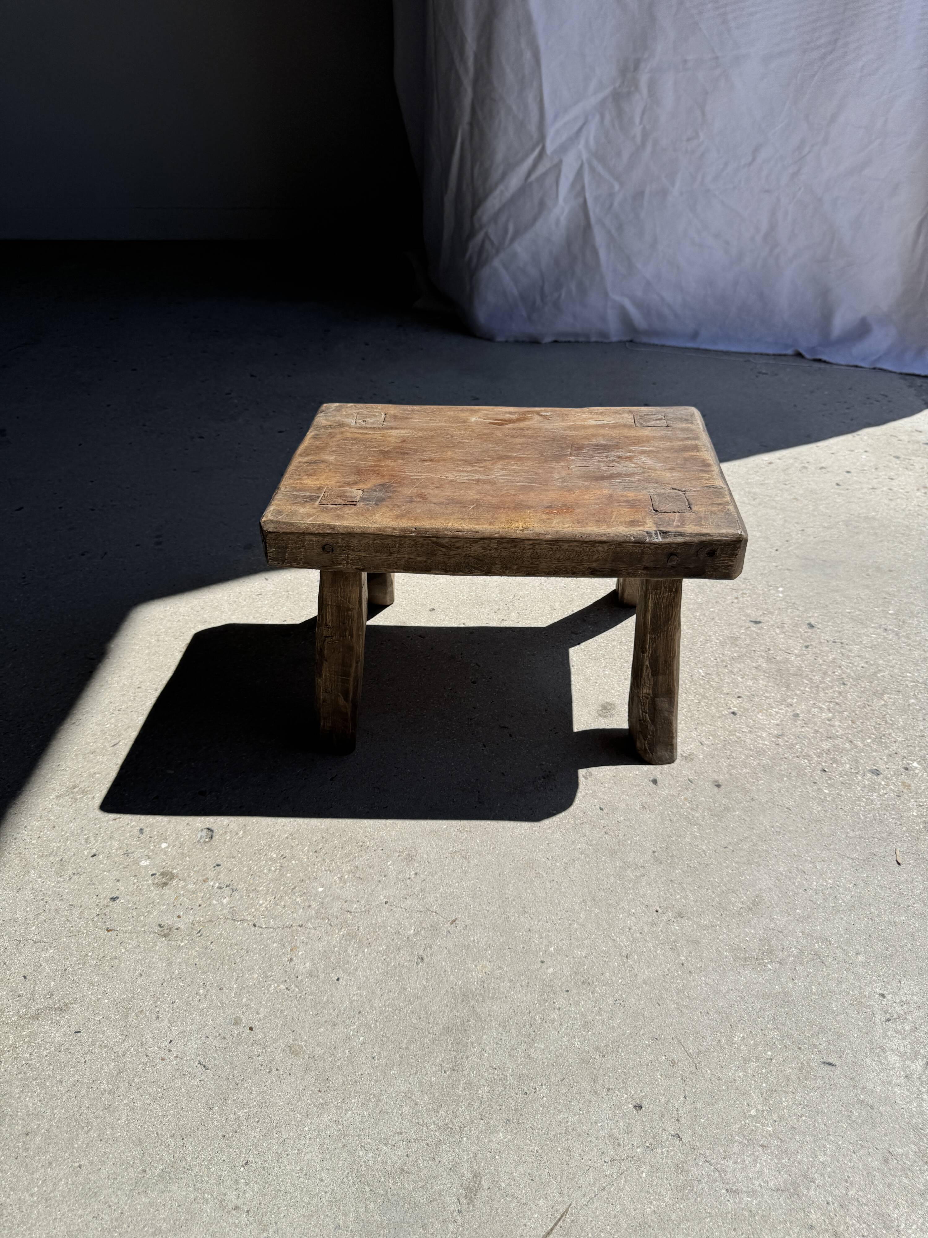 Small stool, rectangular solid teak side table with curved legs.