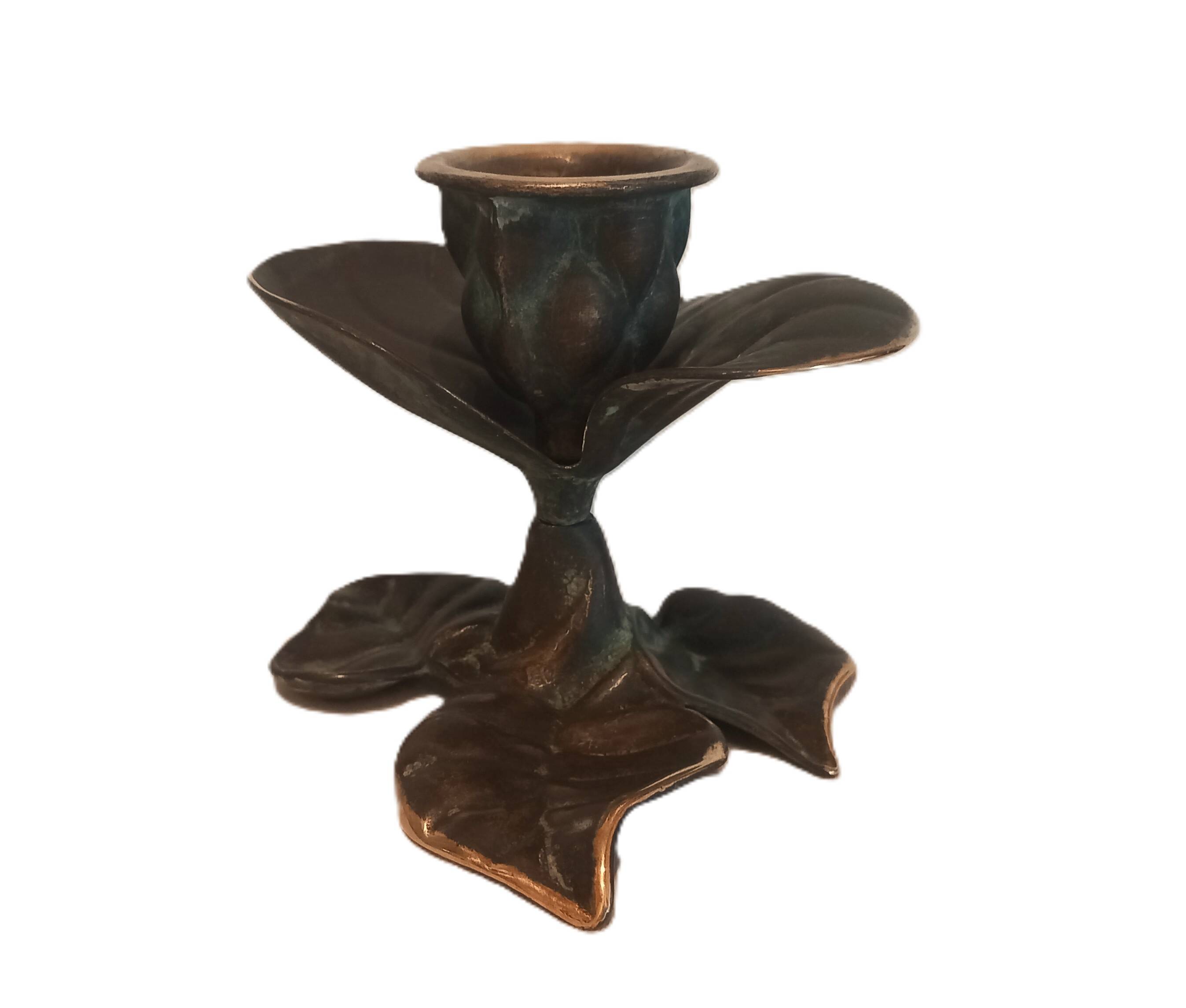 Patinated green brass candlestick with foliage decoration.