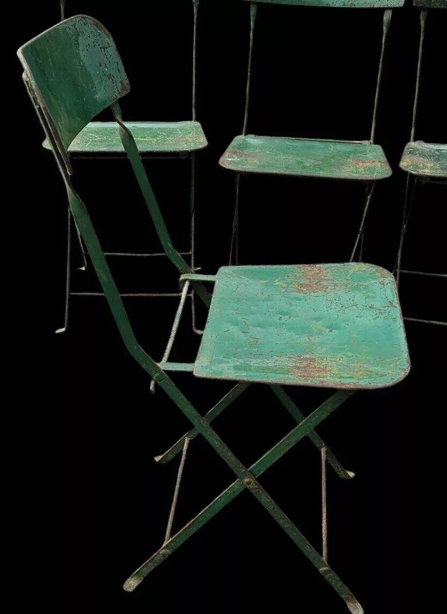 Set of 8 green painted metal industrial folding chairs.