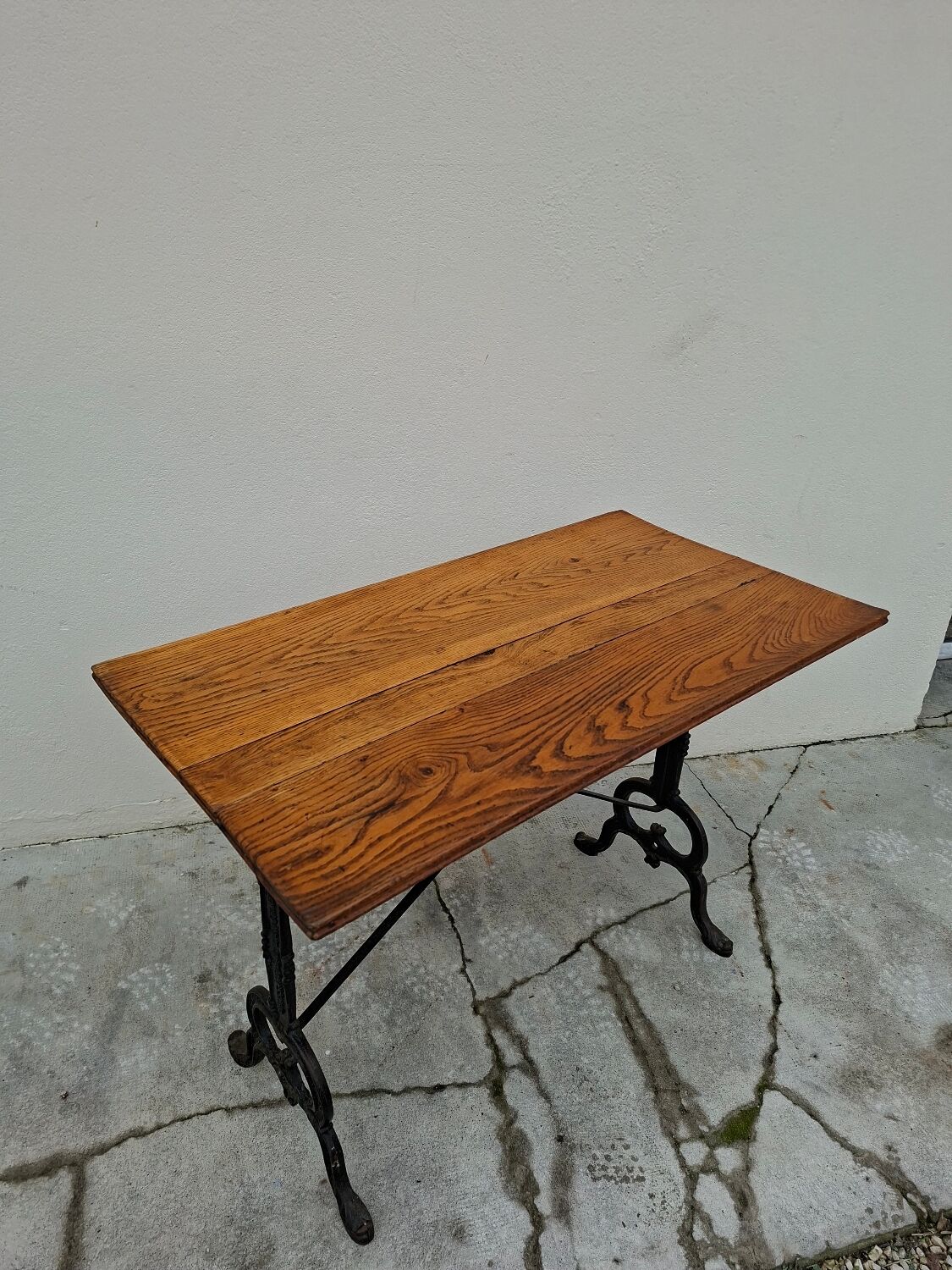 Solid oak bistro table with a cast iron base, signed.