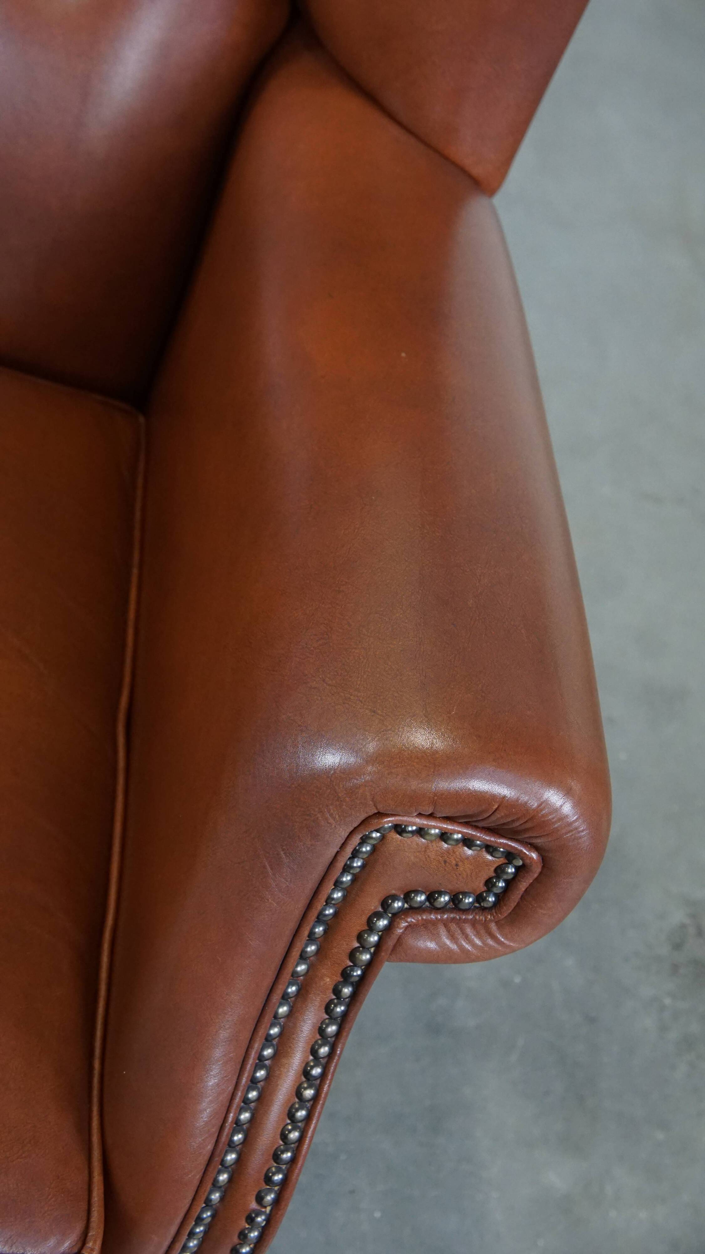 Cognac-colored leather wingback chair in English style