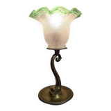 Small table lamp with a brass fish base and a tulip shade with green edges.