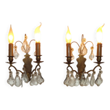 Pair of French antique brass double wall lights with assorted crystals.