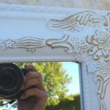 Large wooden mirror on tilting psyche stand in whitewashed gold with molding